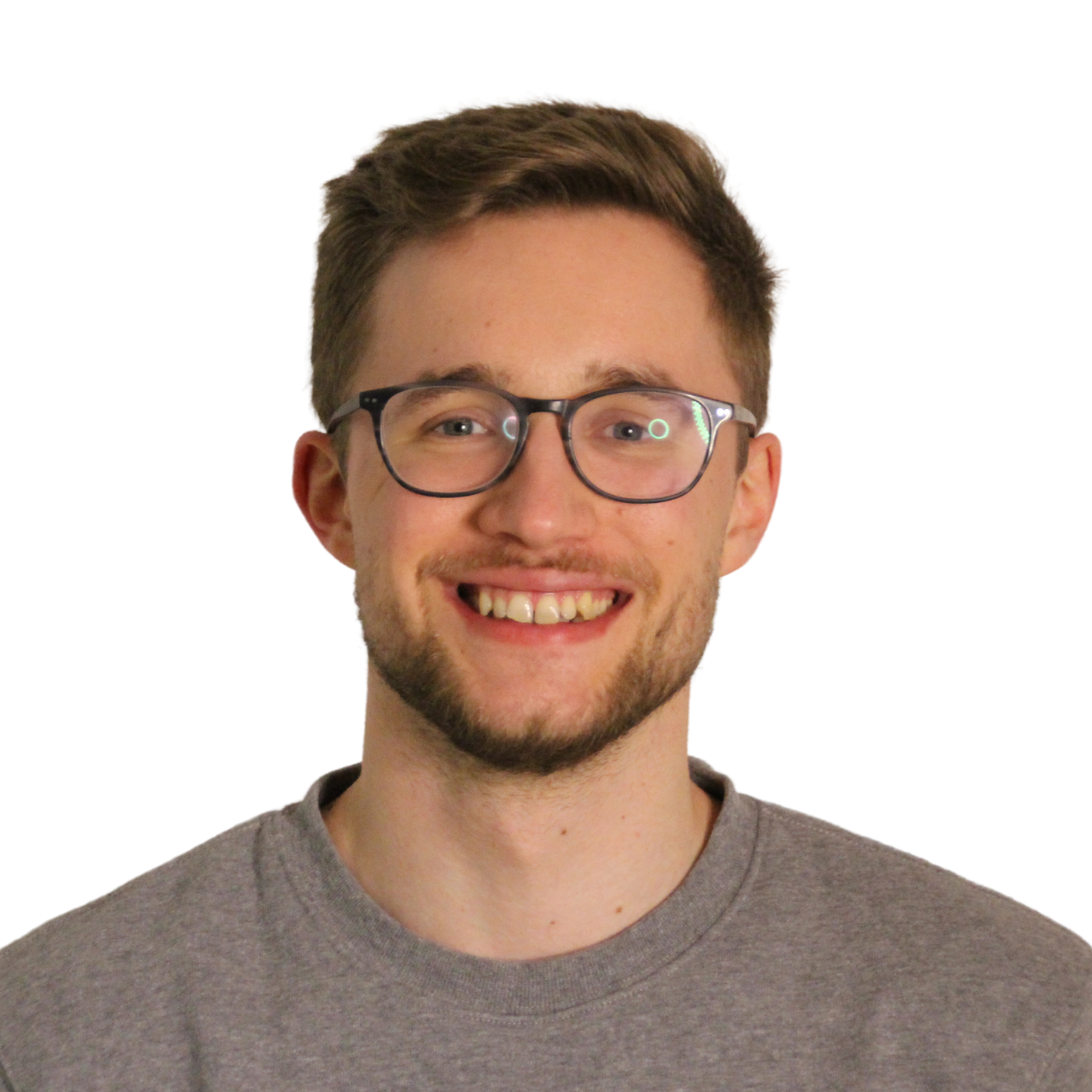 Fynn-Ole_Eisenhuth Porträt von Fynn-Ole Eisenhuth. Ein junger Mann mit kurzen dunkelblonden Haaren lächelt in die Kamera. Er trägt eine Brille, einen Dreitagebart und einen grauen Pullover.