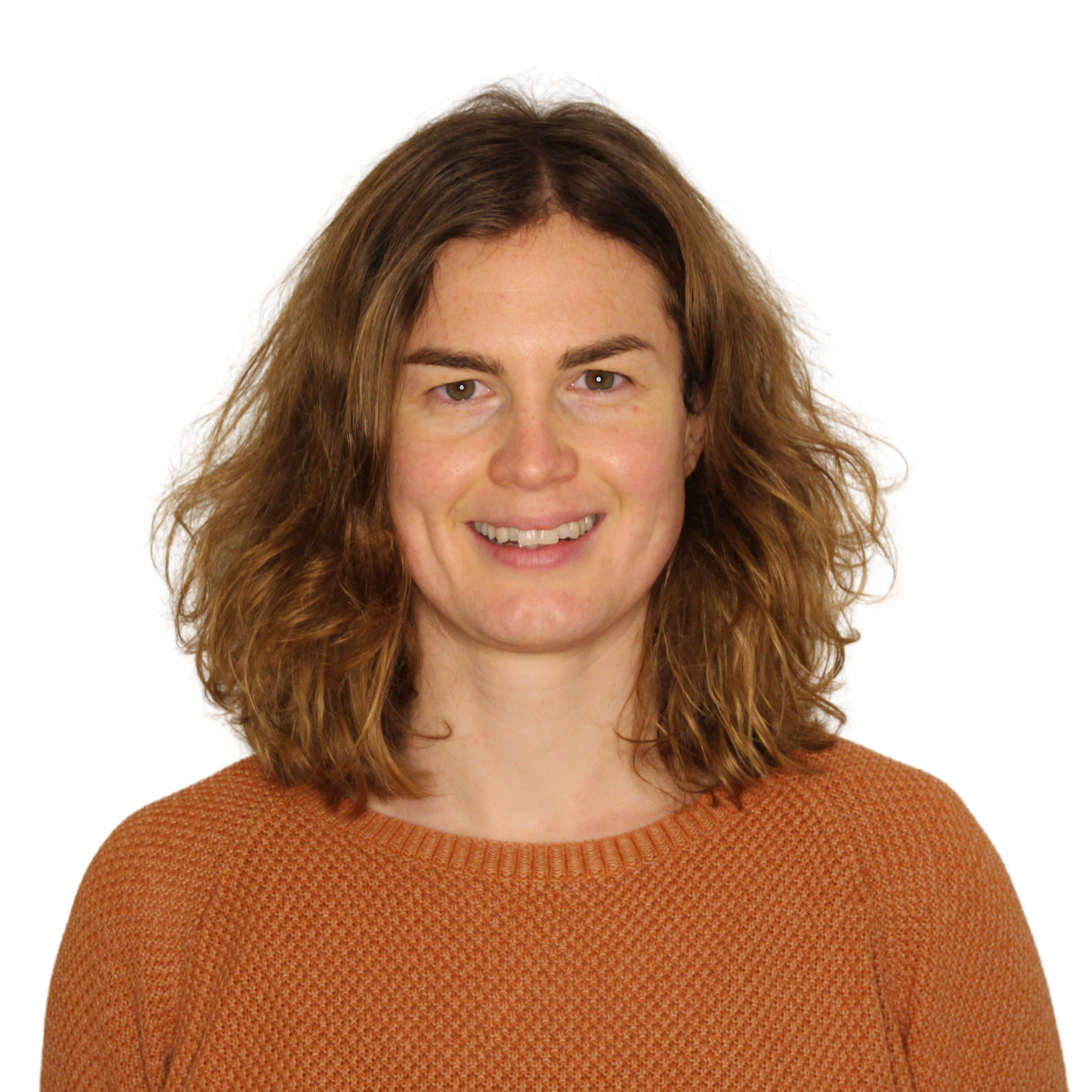 Lea_Lükemeier Porträt von Lea Lükemeier. Eine jüngere Frau schulterlangen dunkelblonden Haaren lächelt in die Kamera. Sie trägt einen orangenen Pullover.