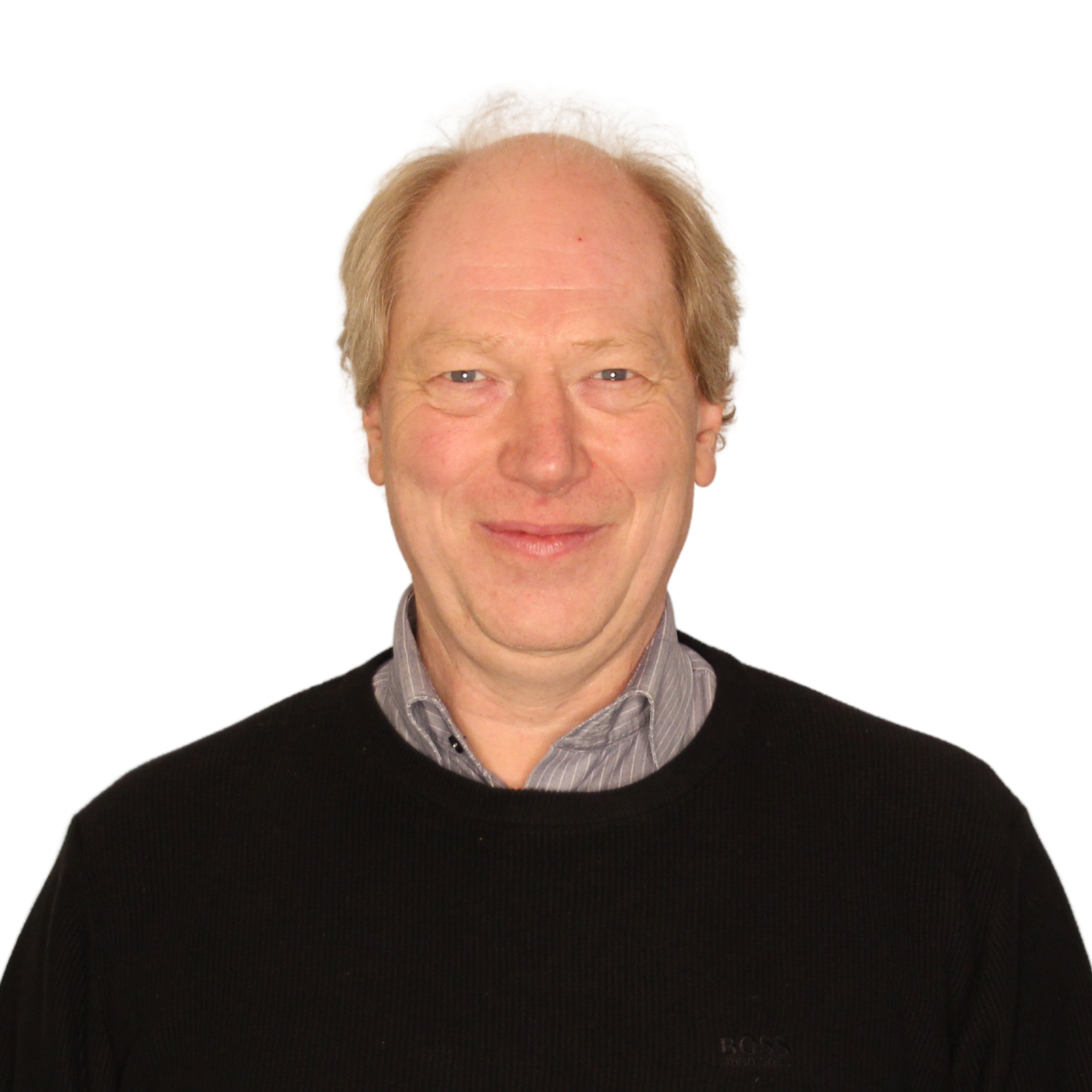 Dirk_Scheelje Porträt von Dirk Scheelje. Er hat kurze blonde Haare und lächelt in die Kamera. Er trägt einen dunklen Pullover mit einem hellen Hemd darunter.