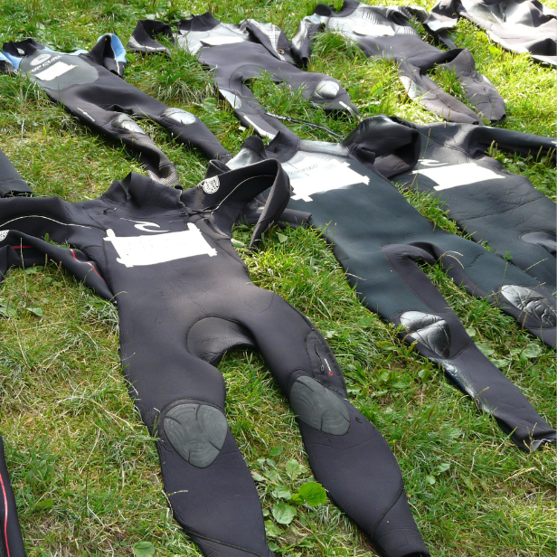 Neoprenazüge trocknen auf einer Wiese.