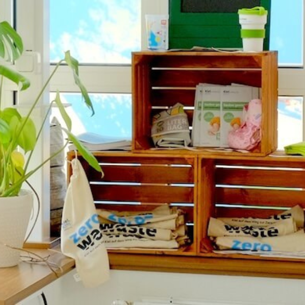 In Holzkistenregalen liegen Beutel von Zero Waste Kiel.