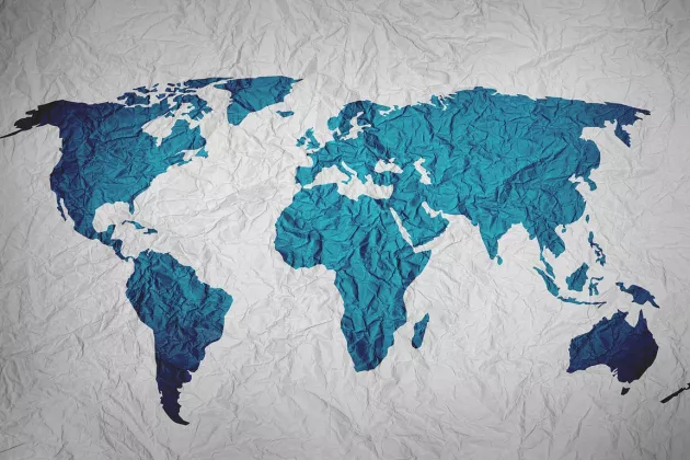 Auf einem knittrigen Papier ist die Weltkarte ins blau hinterlegt. 