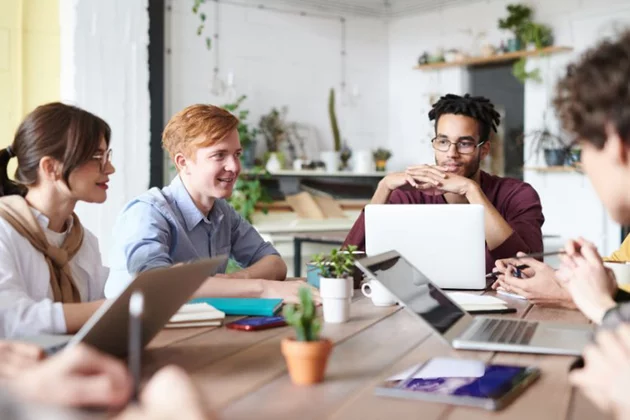 Junge Personen mit Laptop am Tisch