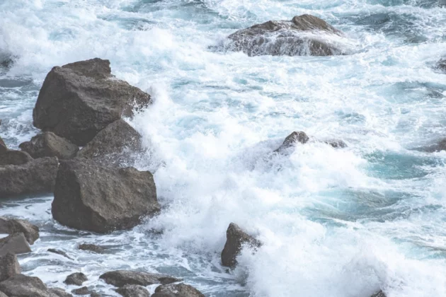 Große Felsen und Steine trotzen der tosenden Brandung. 