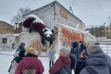 Die CCC-Projektpartner*innen besichtigen Riga. Es liegt viel Schnee. Auf einer Mauer klettert die überdimensionierte Figur eines Fuchses.