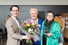 Felix Schartner Giertta (CBSS, Cultural Pearls) übergibt einen Blumenstrauß an Annette Wiese-Krukowska (Referat Kreative Stadt Kiel) und Bürgermeisterin Renate Treutel, die den gläsernen Award in den Händen hält.