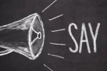 Zu sehen ist ein mit Kreide gemaltes Megaphon, links im Bild. Rechts daneben steht in Kreide "Say no".