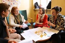 Vier Vertreter*innen/Teilnehmer*innen des BSR Programms Cultural Pearls sitzen gemeinsam an einem Tisch und arbeiten.