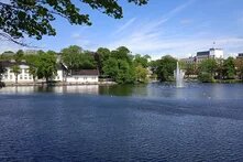 Gemeinde Eigersund. Im Vordergund Wasser, im Hintergrund die Satdt umgeben von grün bewachsenen Bäumen.