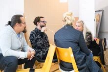 Vier Personen sitzen zusammen und unterhalten sich.