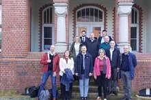 Ein Gruppenfoto von Menschen, die vor einem Gebäude stehen.