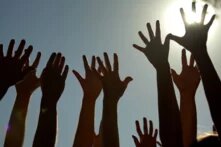 Hoch gestreckte Hände vor der Sonne