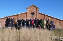 Eine Gruppe an Menschen steht gemeinsam für ein Gruppenfoto vor einem Gebäude. Es handelt sich hier um ein Partnermeeting in Dänemark im Projekt Liveability.