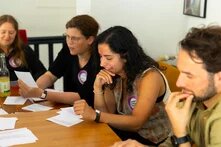 Böll-SH-Mitarbeiterin Ghader Al Holu sitzt mit drei anderen Personen an einem Tisch beim Vernetzungstreffen Plurale Erinnerungskultur.