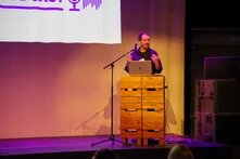 David Manthey steht auf einem Podium und hält einen Vortrag bei der Abschlusskonferenz von Data for All.