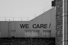 Auf einer Hausfassade steht "We care!"