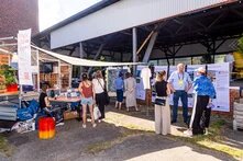 Waterkant Festival: Leute stehen an einer Outdoor-Ausstellung. Einige unterhalten sich, andere lesen informative Banner.