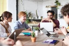 Junge Personen mit Laptop am Tisch