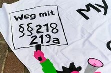 Demo-Banner beim Safe Abortion Day mit der Aufschrift "Weg mit §§ 218 und 219a"