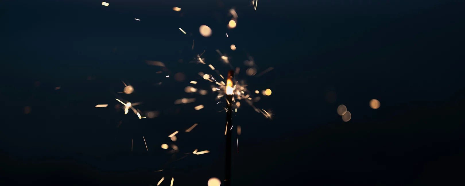 Funken von einem Feuerwerk vor dunklem Hintergrund.