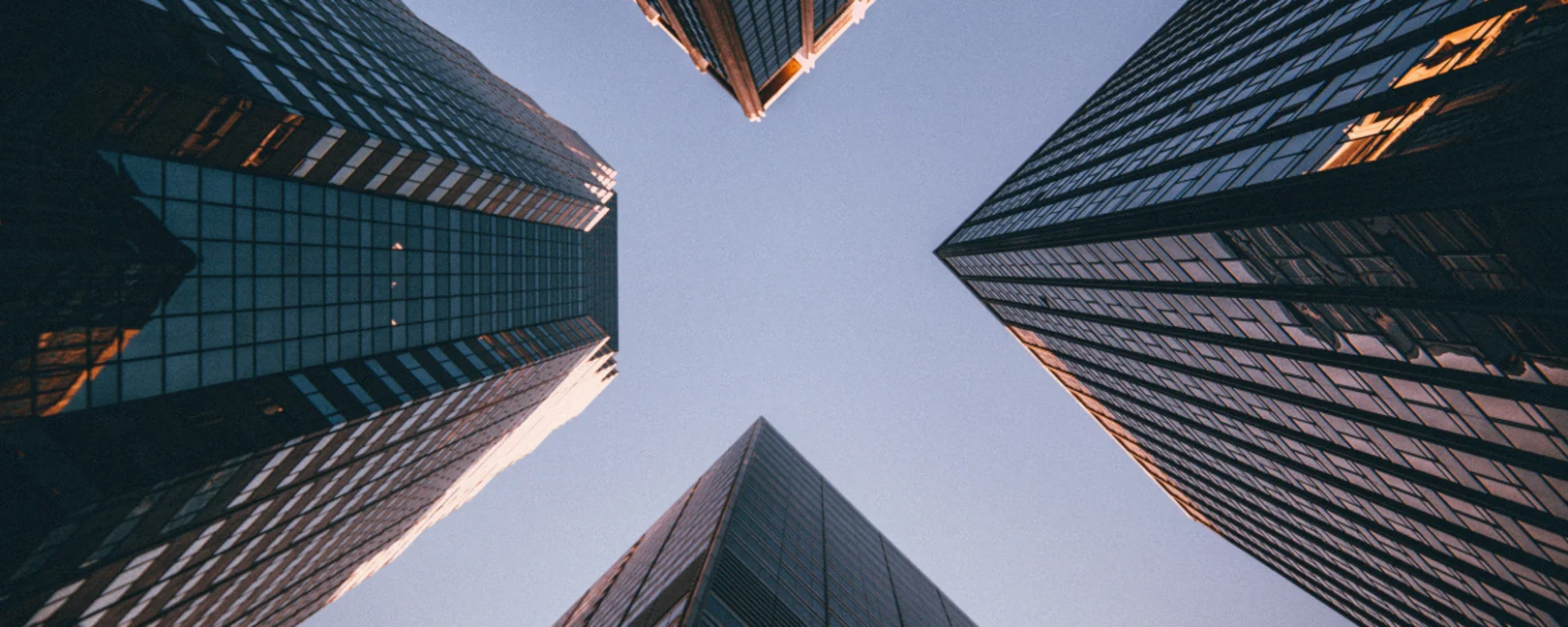 Vier Skyscraper. die von unten fotografiert sind.