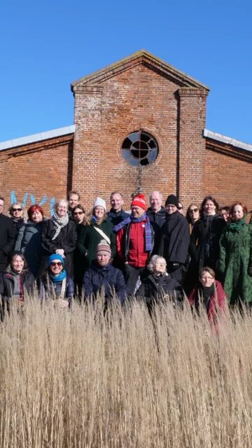 Eine Gruppe an Menschen steht gemeinsam für ein Gruppenfoto vor einem Gebäude. Es handelt sich hier um ein Partnermeeting in Dänemark im Projekt Liveability.