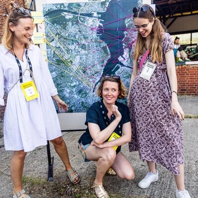 Drei Personen vor einer Karte. Gruppenfoto.