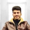Porträt von Amanj Mohammed. Er hat dunkle Haare und einen Dreitagebart.