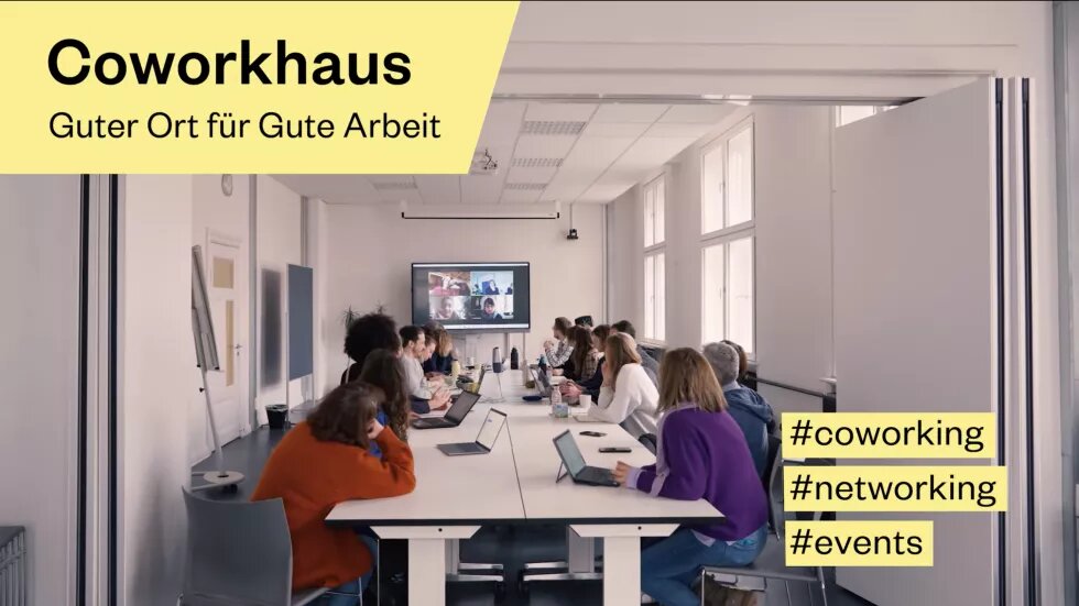 Coworkhaus Anscharcampus Mittig sitzen viele Menschen um einen Konferenztisch herum. Am Ende der Raums ist ein Bildschirm, auf dem weitere Leute dazugeschaltet sind. Links oben steht: Corworhaus, guter Ort für gute Arbeit. Unten rechts steht #coworking #networking #events