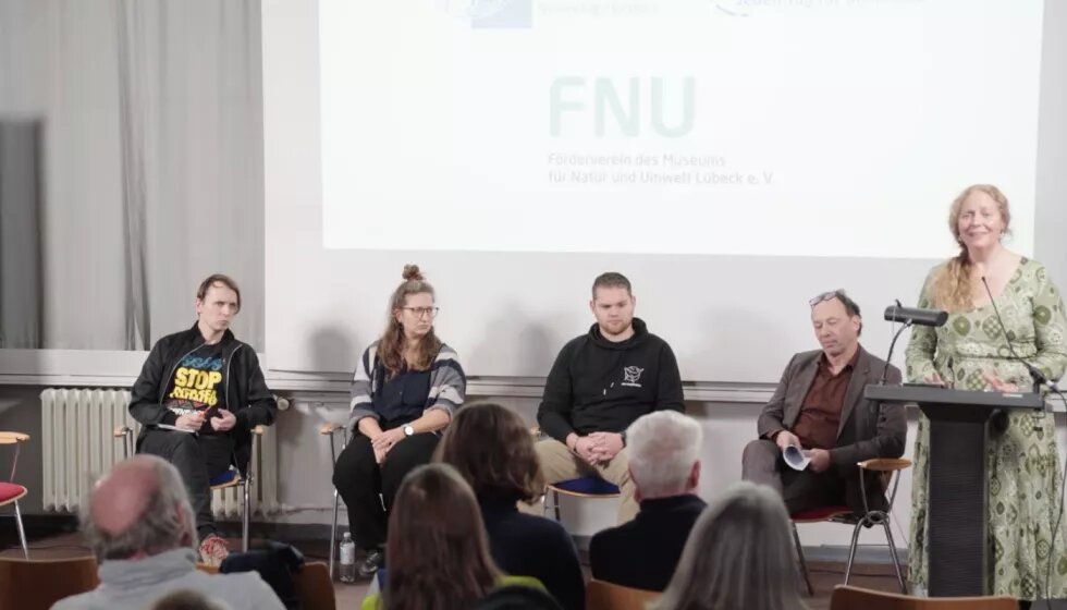 Die Teilnehmenden der Lesung "Braucht der Meeresschutz mehr zivilen Ungehorsam?" sitzen auf dem Podium.