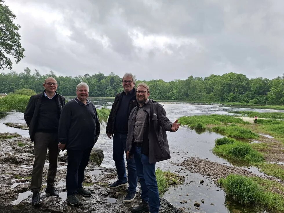 Michael Krug, Gilbert Sieckmann-Joucken, Thomas Leidreiter und Christian Andresen stehen vor einem Flusslauf in Lettland.