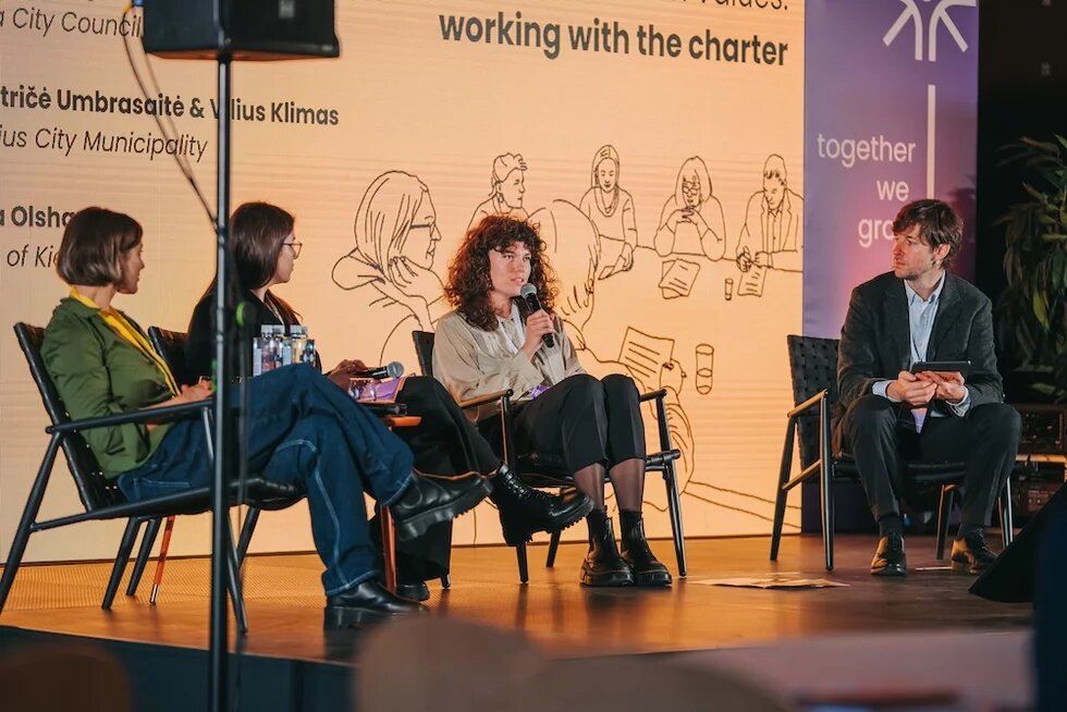 Auf einer Bühne unterhalten sich 12. Insa Olshausen, Anita Amālija Olava, Beatričė Umbrasaitė Viesturs Celmiņš.