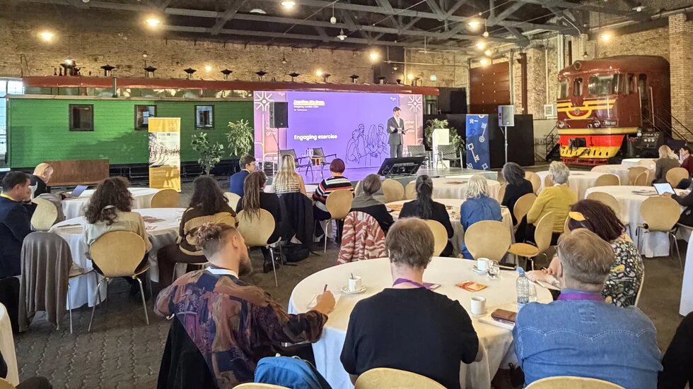 Die Location von Together we Grow im lettischen Eisenbahnmuseum. Rechts steht in einer Halle ein Zug auf Schienen.