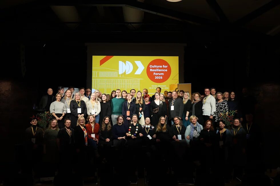 Teilnehmende des Culture for Resilience Forums stehen für ein Gruppenfoto auf der Bühne.