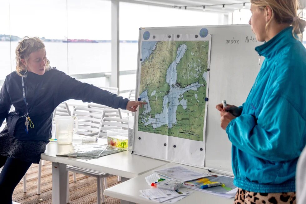 Zwei Mitarbeitende von Snorkeling City erklären etwas anhand einer Karte.