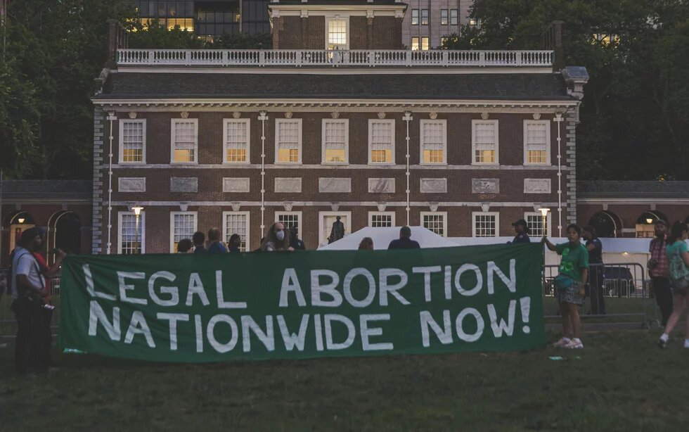 Menschen halten einen Banner hoch "Legal abortion nationwide now!